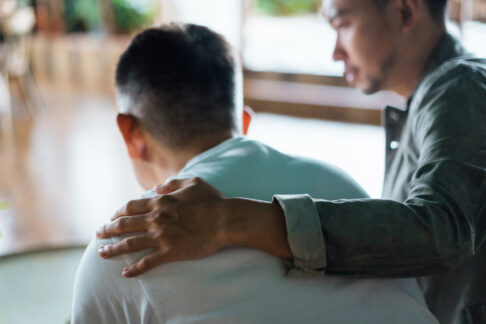 Un jeune homme prenant soin de son père et en le réconfortant en posant sa main sur son épaule