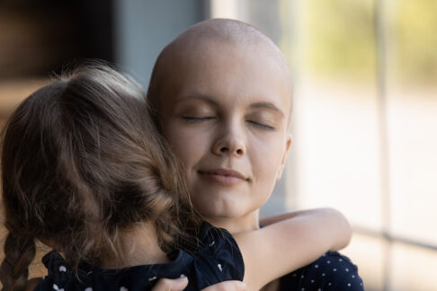 une mère atteinte d'un cancer enlace sa petite fille et la serre dans ses bras