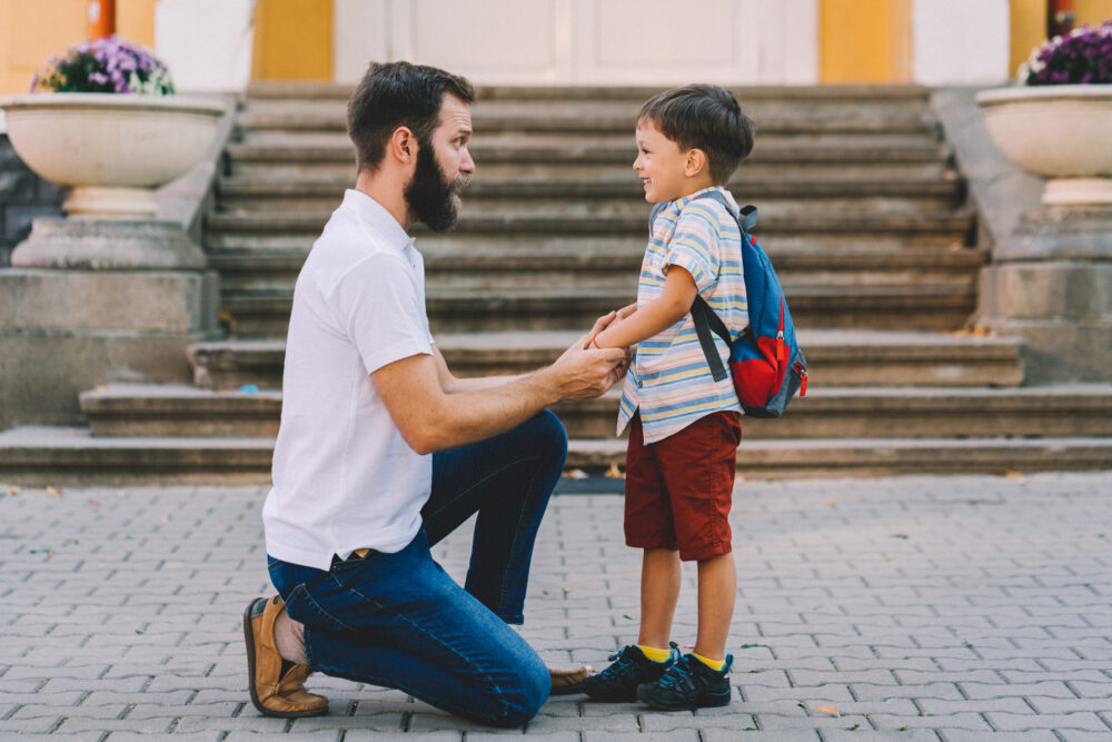 Un père déposant son fils pour son premier jour d'école